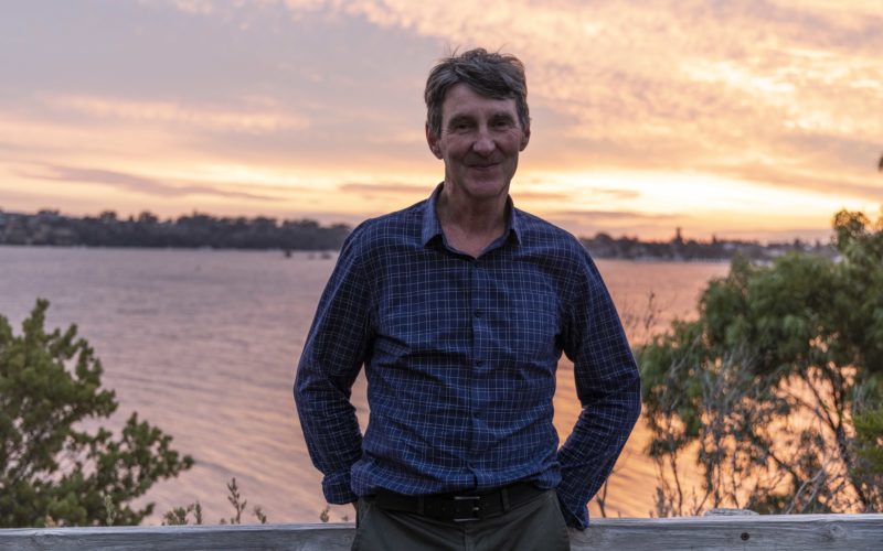 Image of Brendan Edgar standing at a lookout over the Swan River, WA at sunset.