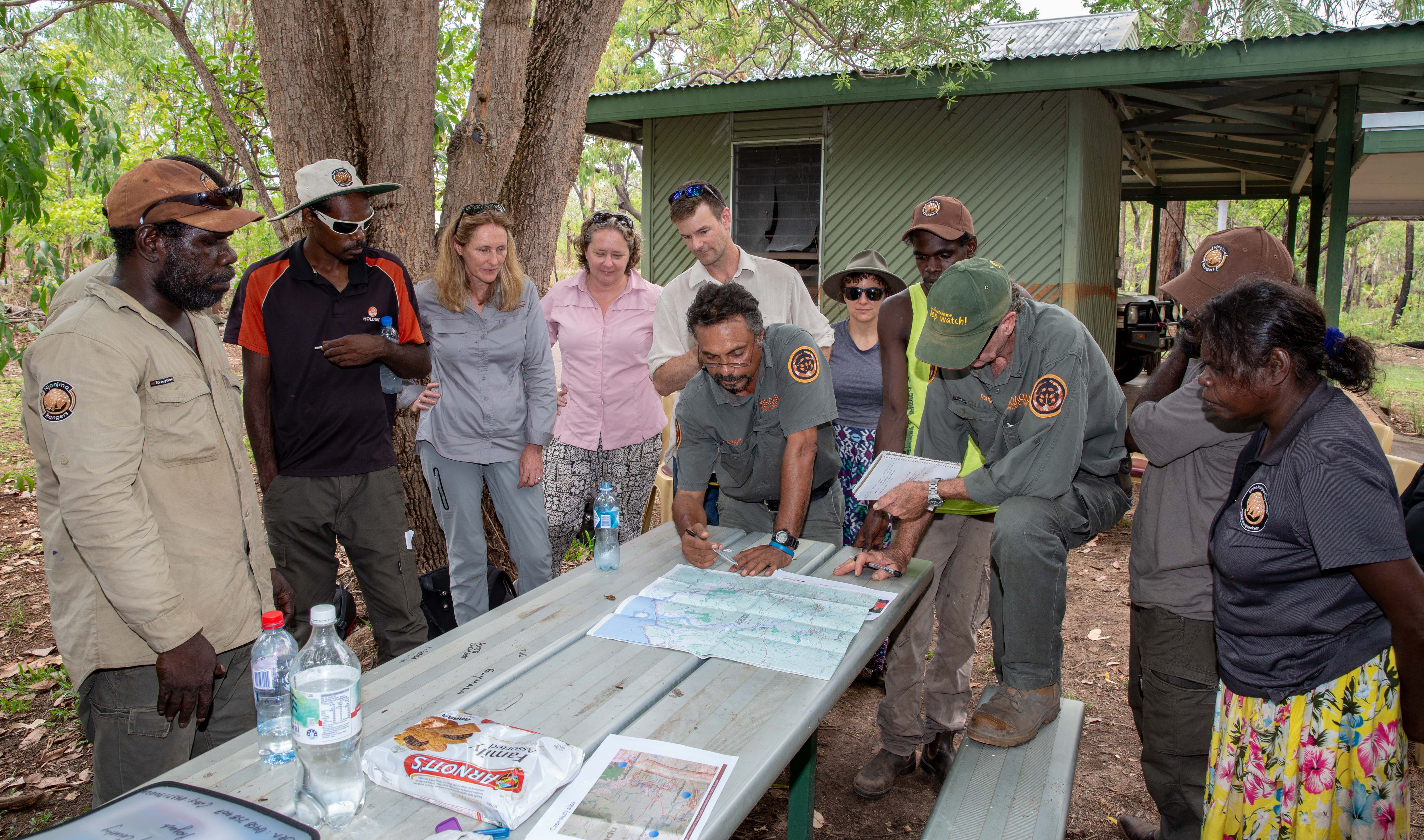 Bininj/Mungguy Research Steering Committee, Kakadu staff and Researchers assess maps at table