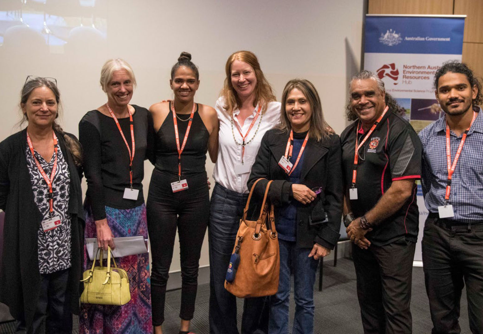 Photo of Natalie Stoeckl, Diane Jarvis, Celia Boxer, Jane Addison, Sharon Prior, David Hudson and Emile Boxer – researchers, co-researchers and collaborators. This group of seven are standing in front of a projector and pull-up banner.