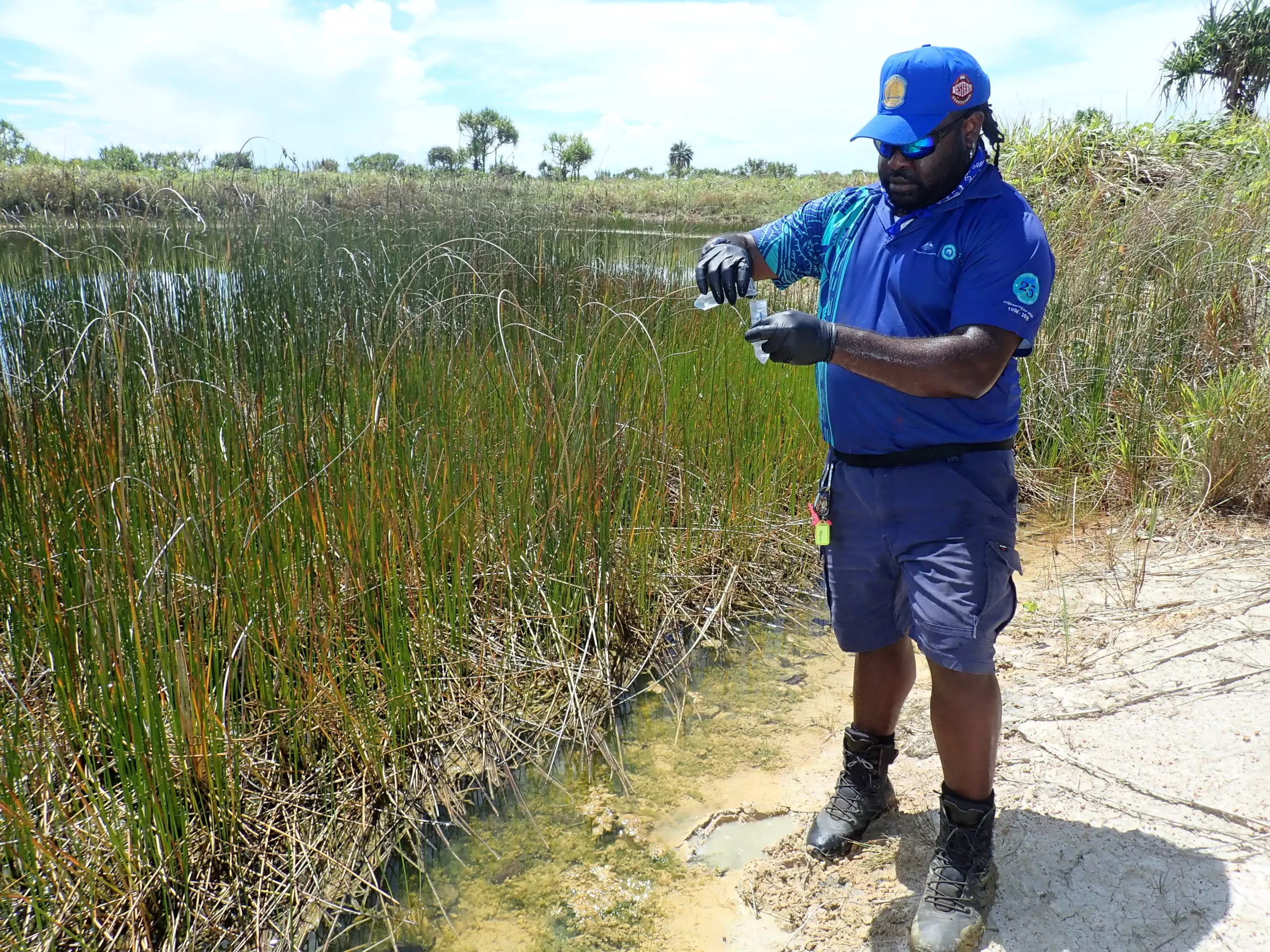 Torres Strait Regional Authority, Land and Sea Management Unit Mura Buway Ranger Jehemess Waia collecting eDNA samples from Saibai water body