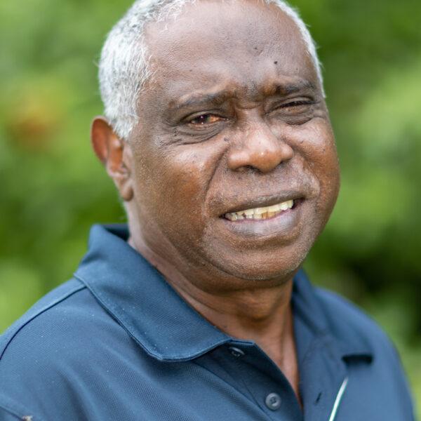 A man in a blue shirt smiling at the camera